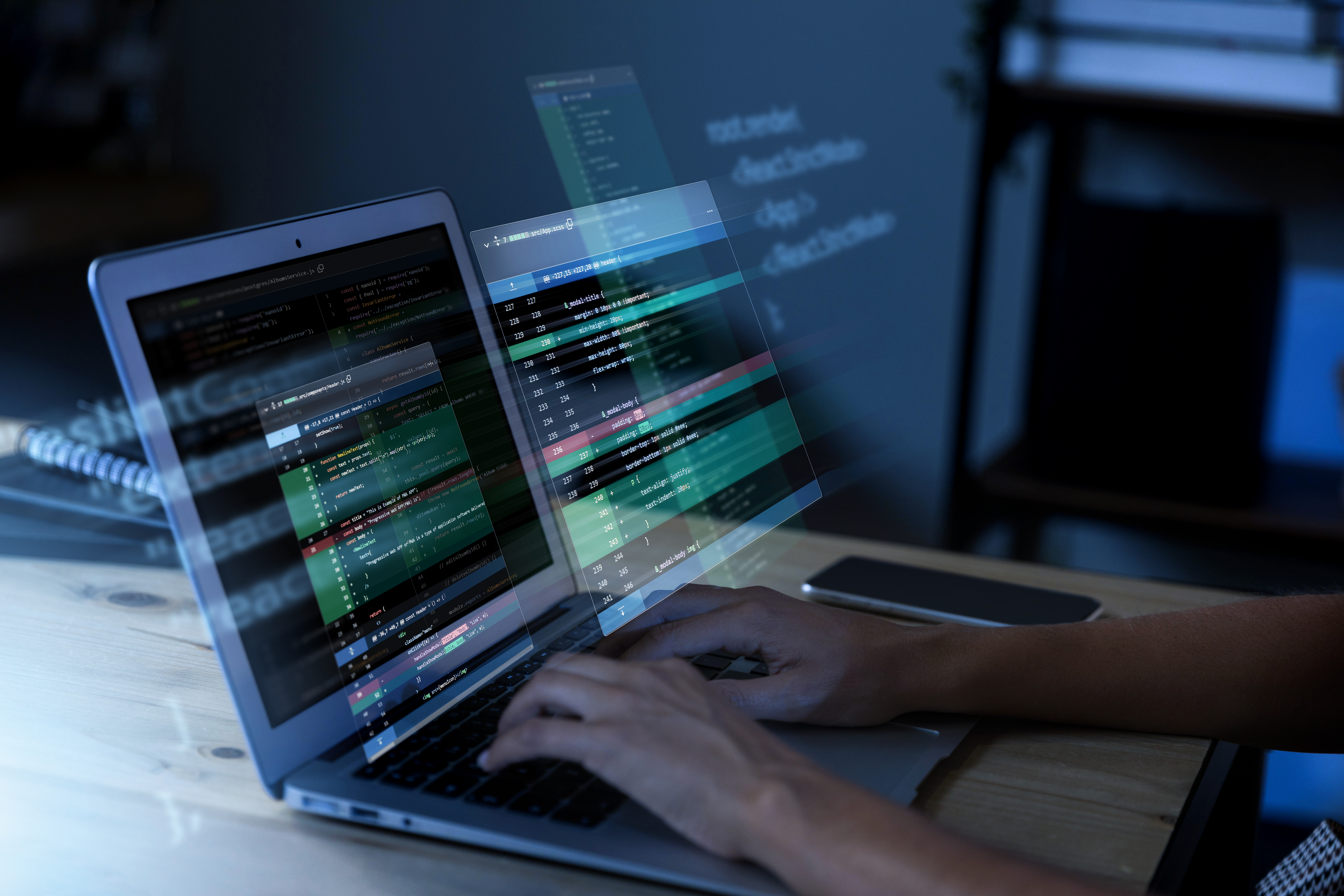 Person working on a laptop with holographic cybersecurity data projections, representing IoT network protection and data encryption.