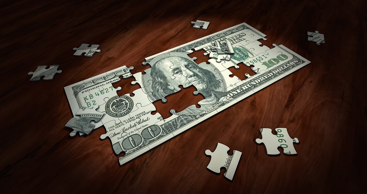 Incomplete puzzle of a hundred-dollar bill on a wooden surface, symbolizing financial strategy and problem-solving