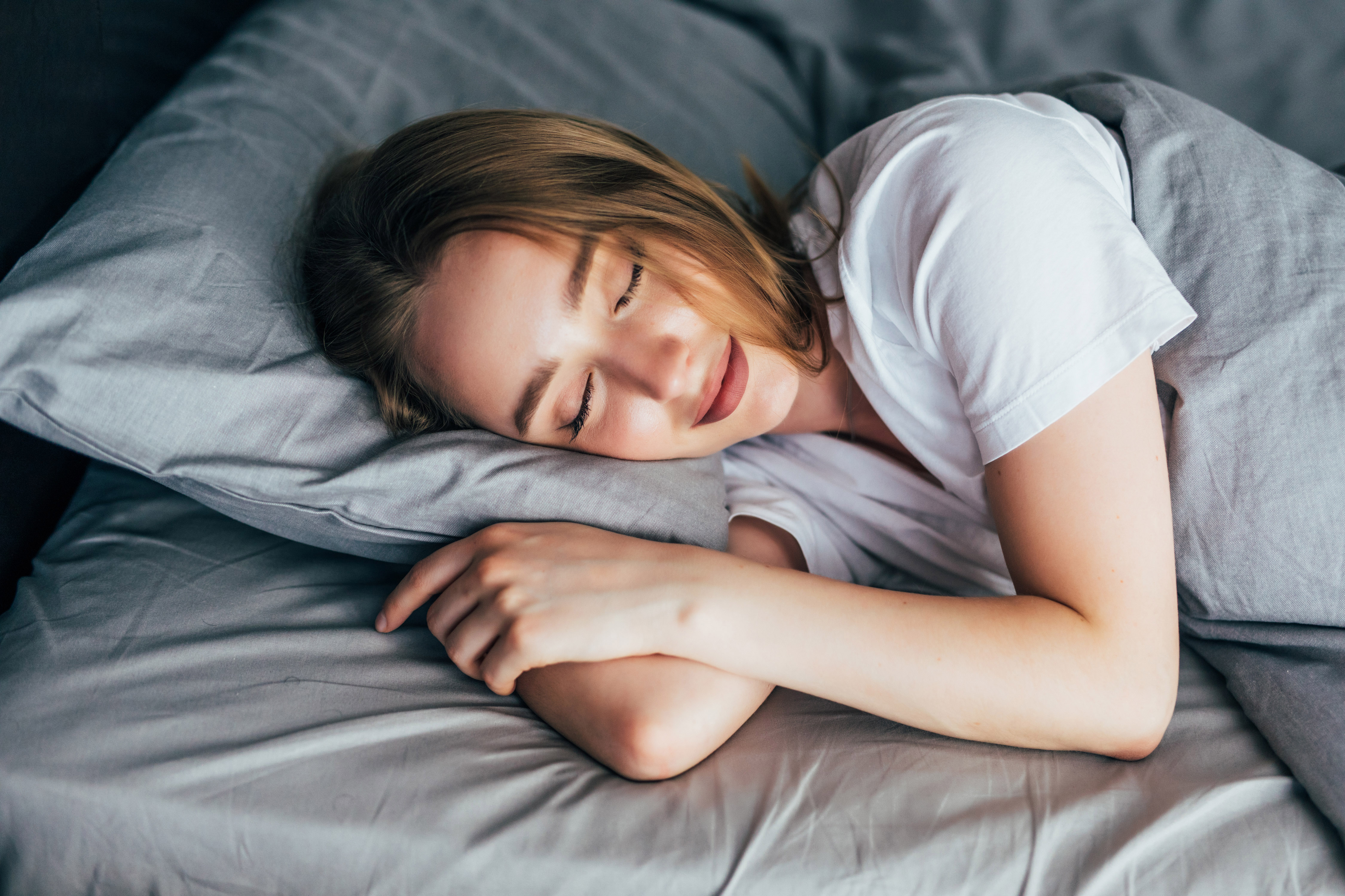 Woman sleeping peacefully in bed while traveling